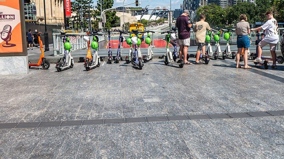 Trottinettes électriques en libre-service alignées sur une place piétonne