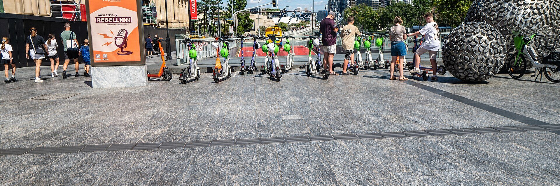 Trottinettes électriques en libre-service alignées sur une place piétonne